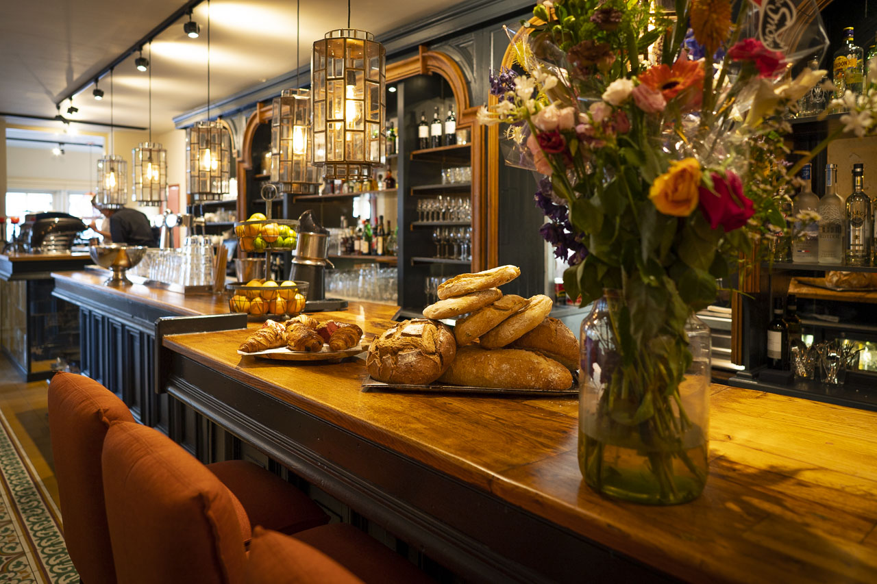 De warme bar van Restaurant Maximiliano met vers brood en een boeket bloemen