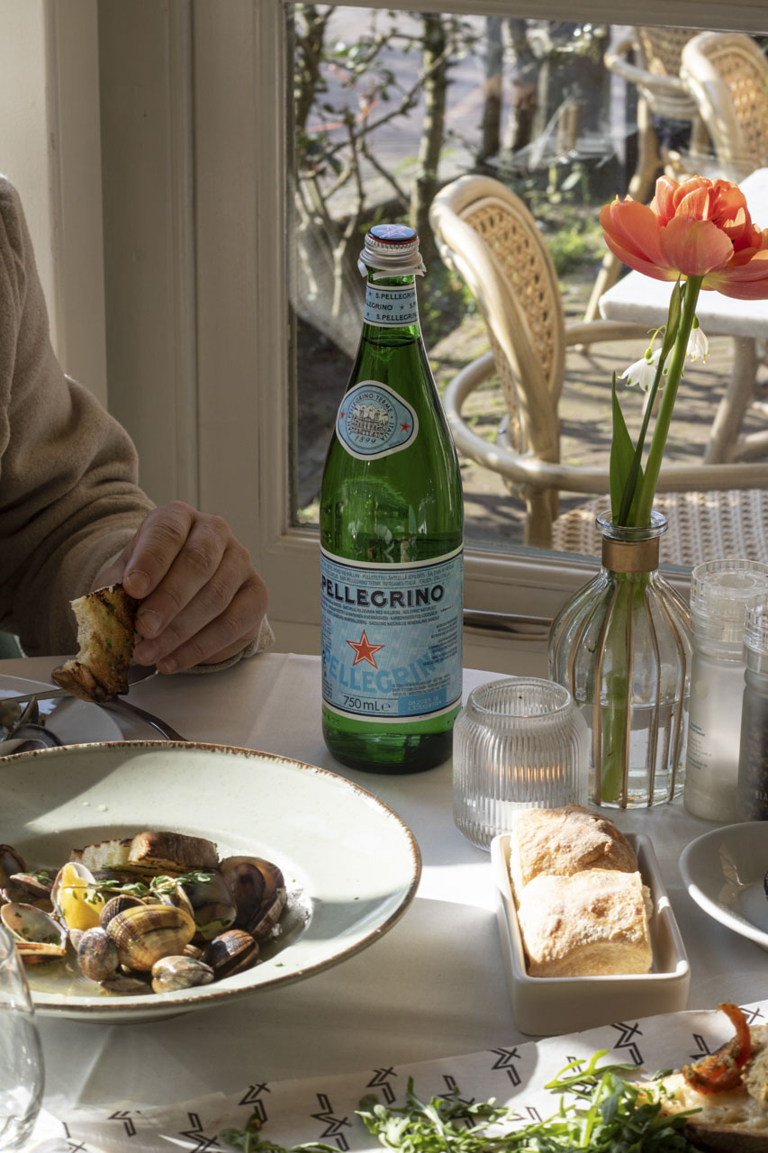 Spaghetti vongole aan een zonnige tafel bij het raam bij Maximiliano